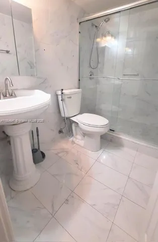 a bathroom with a toilet sink and shower