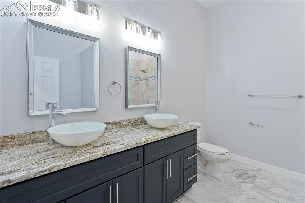 8081 Granger Road Rye, CO 81069 - Photo 38 of 42 a bathroom with a granite countertop double vanity sink and a mirror