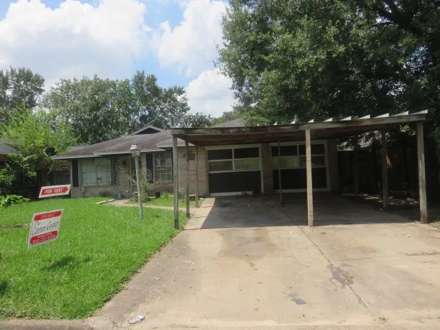a front view of house with a garden and trees