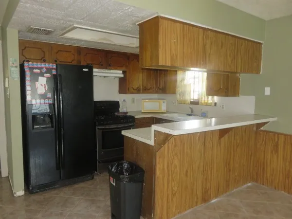 a kitchen with a sink refrigerator and cabinets