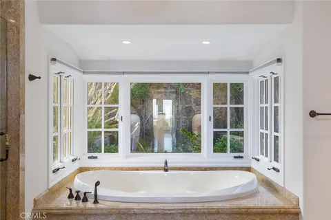 a white bath tub sitting in a bathroom next to a window