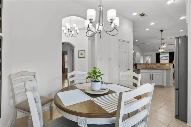 a view of a dining room with furniture a chandelier and wooden floor