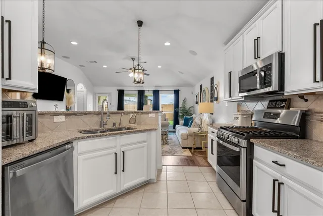a kitchen with stainless steel appliances granite countertop a sink stove oven and cabinets