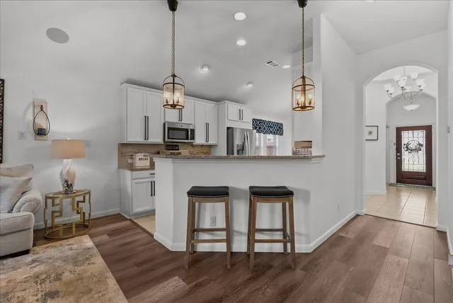 a open kitchen with stainless steel appliances granite countertop a stove refrigerator and cabinets