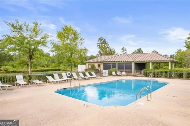 a view of a house with pool and a yard