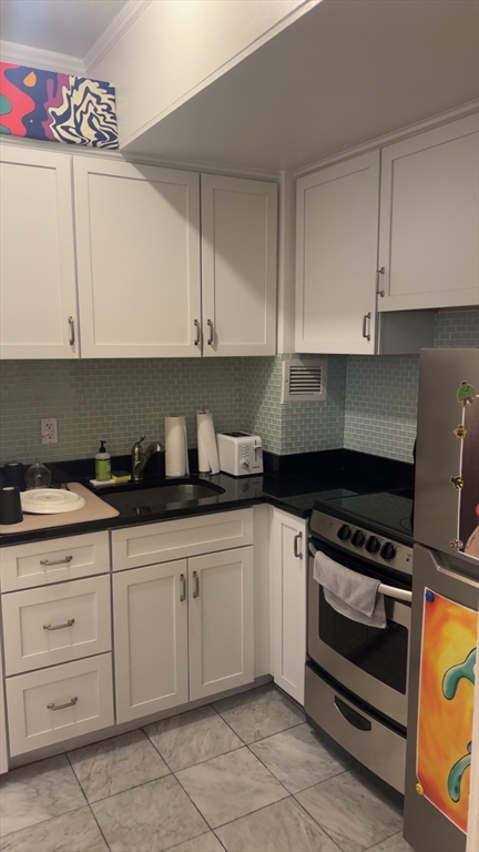 21 Beacon Street, Unit 6D Boston, MA 02108 - Photo 11 of 21 a kitchen with granite countertop a stove sink and cabinets