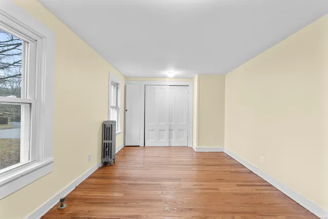 a view of a big room with wooden floor and windows