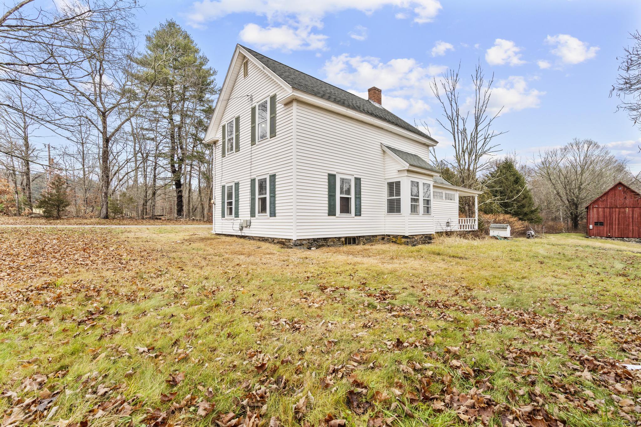 162 Scotland Road Windham, CT 06280 - Photo 3 of 31 a front view of a house with a yard covered with trees