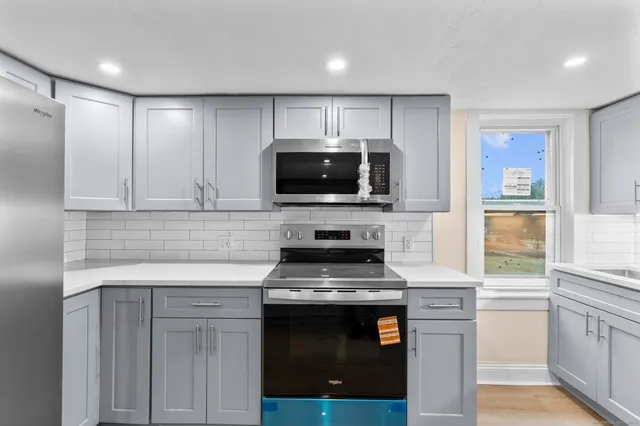 a kitchen with granite countertop a stove and a microwave