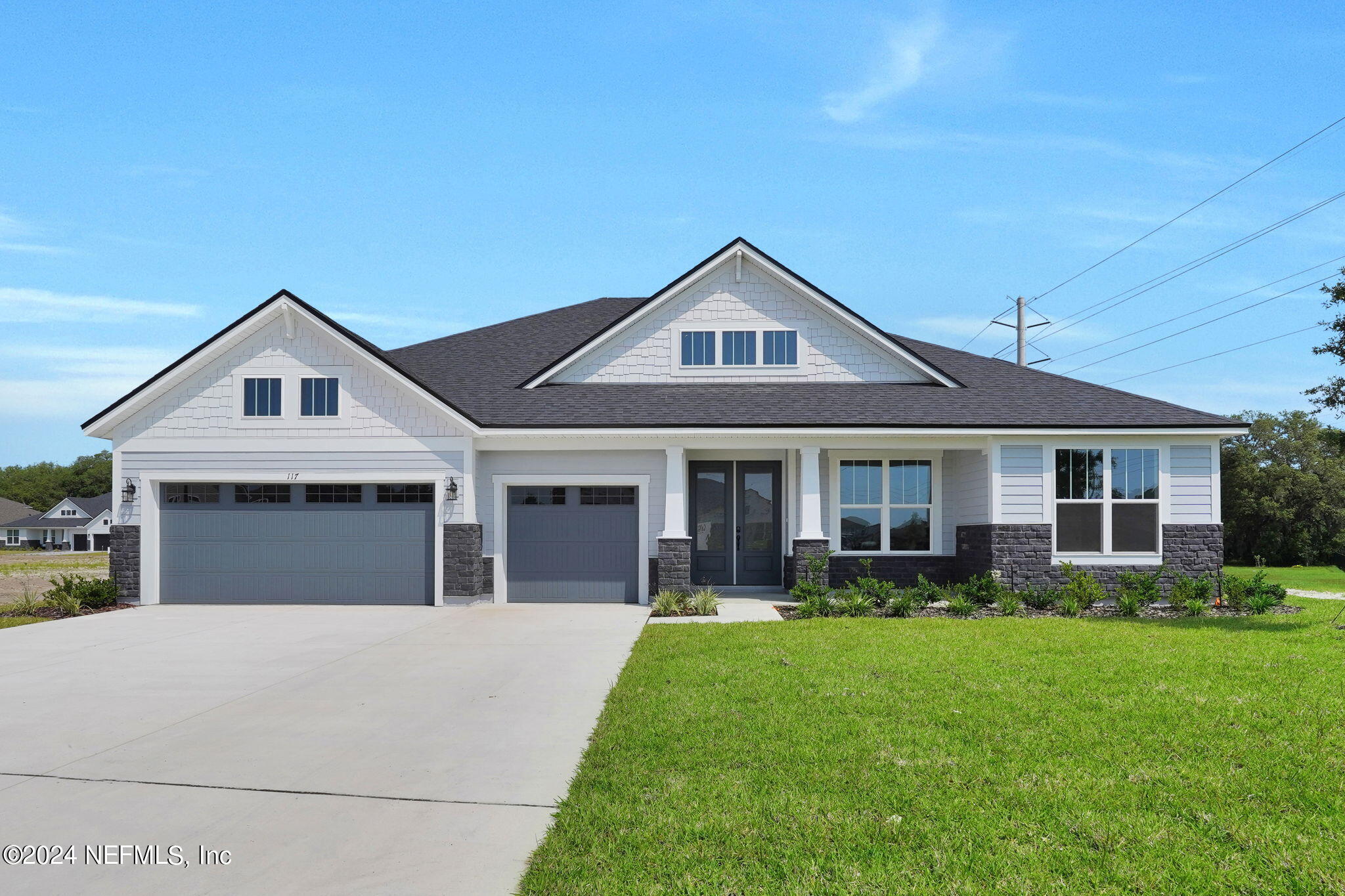a front view of a house with a yard and potted plants