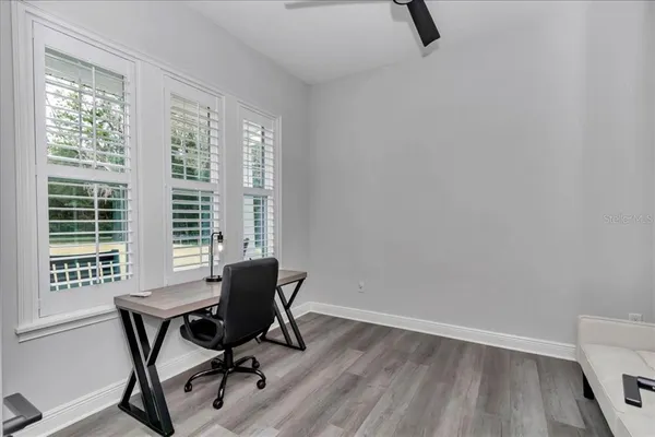 a view of a workspace with furniture and a window