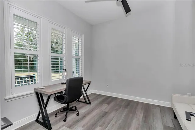 a view of a workspace with furniture and a window