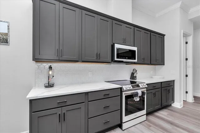 a kitchen with stainless steel appliances granite countertop a sink a stove a microwave and cabinets