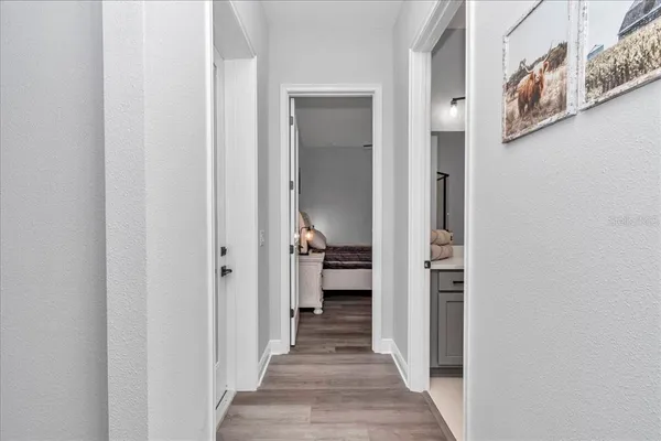 a view of a hallway with wooden floor and staircase