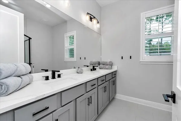 a bathroom with double sink and a mirror
