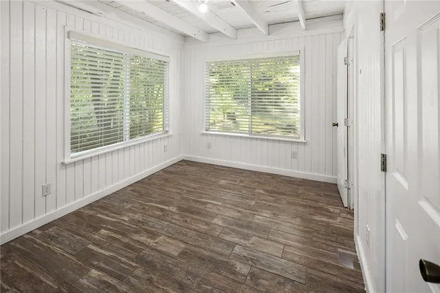 a big room with wooden floor and windows