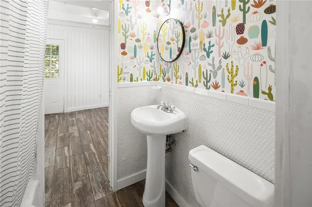 a bathroom with a sink a toilet and a mirror