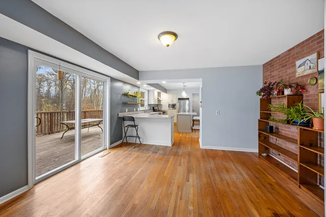 a view of a living room and kitchen with furniture wooden floor and windows