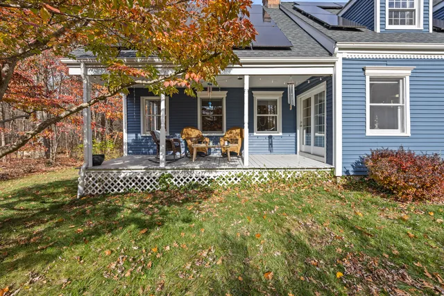 a view of a house with backyard and sitting area