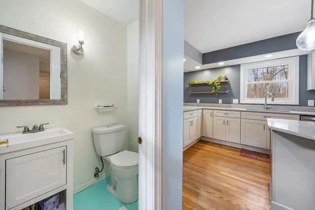 a bathroom with a granite countertop toilet sink and mirror