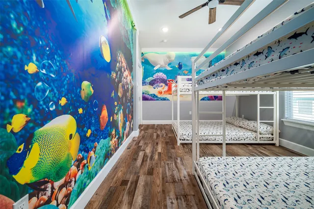 a bedroom with a bed and walk in closet with wooden floor