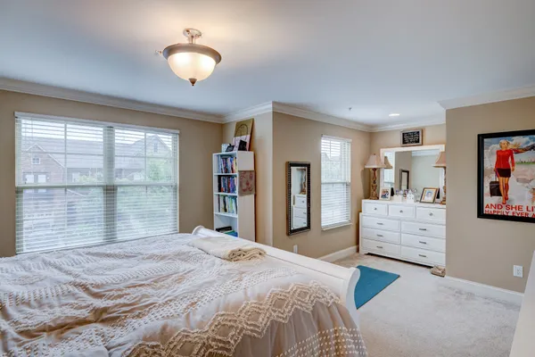 a bedroom with a bed and a large window