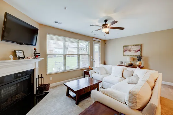 a living room with furniture a fireplace and a flat screen tv