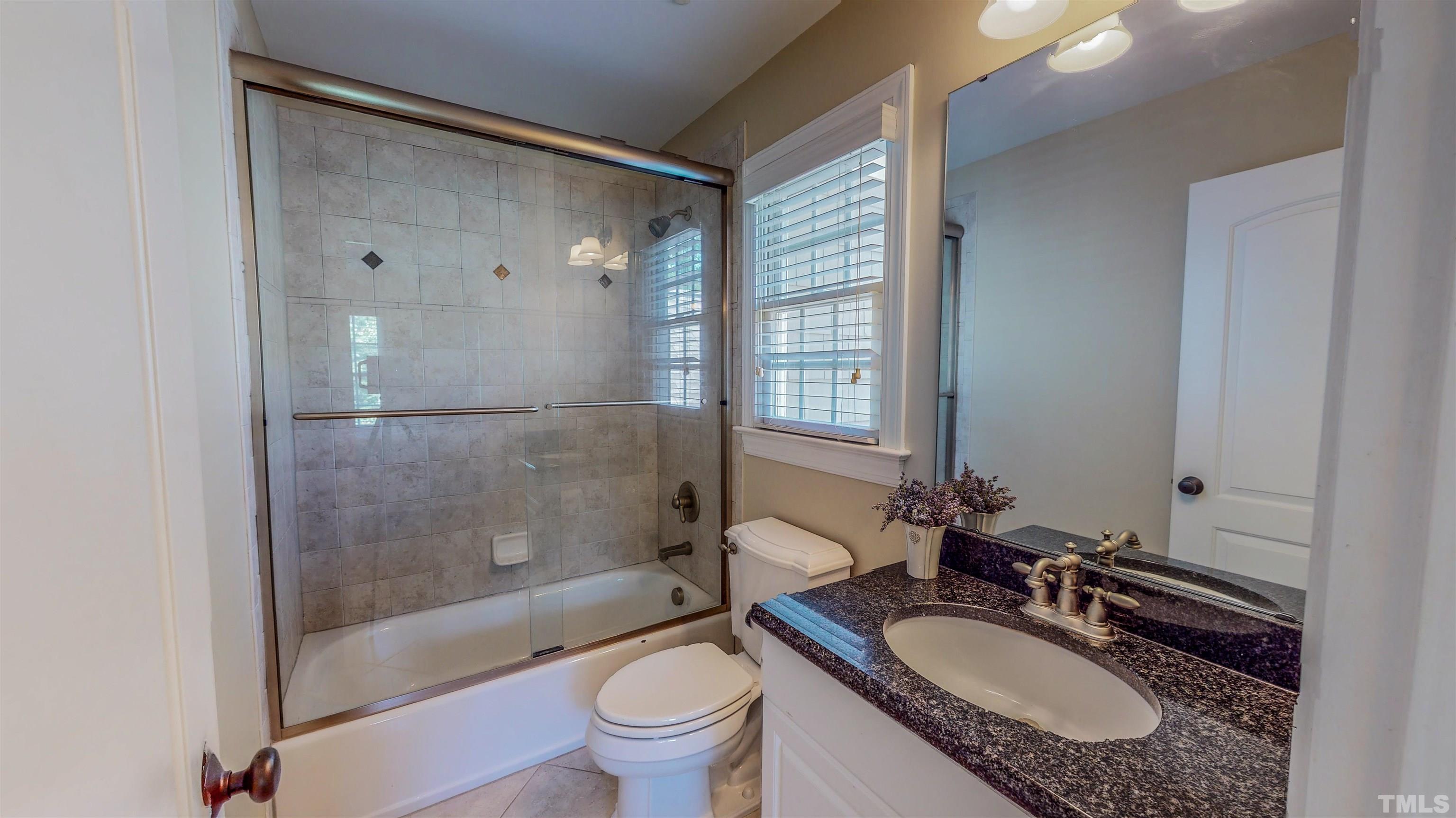 102 Continental Drive Durham, NC 27712 - Photo 41 of 86 a bathroom with a granite countertop sink toilet mirror and shower