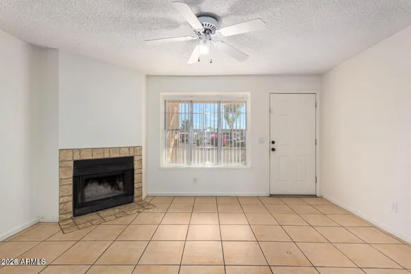 a view of an empty room with a fireplace and a window