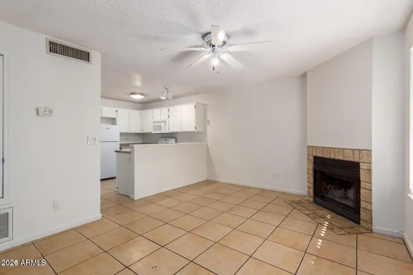 a view of kitchen and empty room with wooden floor
