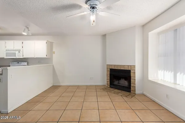 a view of an empty room with a fireplace and a window