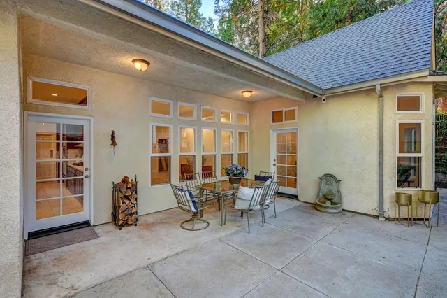 a view of a patio with table and chairs and a barbeque