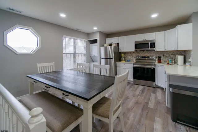 a kitchen with a table chairs refrigerator and cabinets