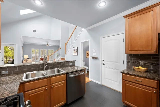 a kitchen with granite countertop a sink and a refrigerator