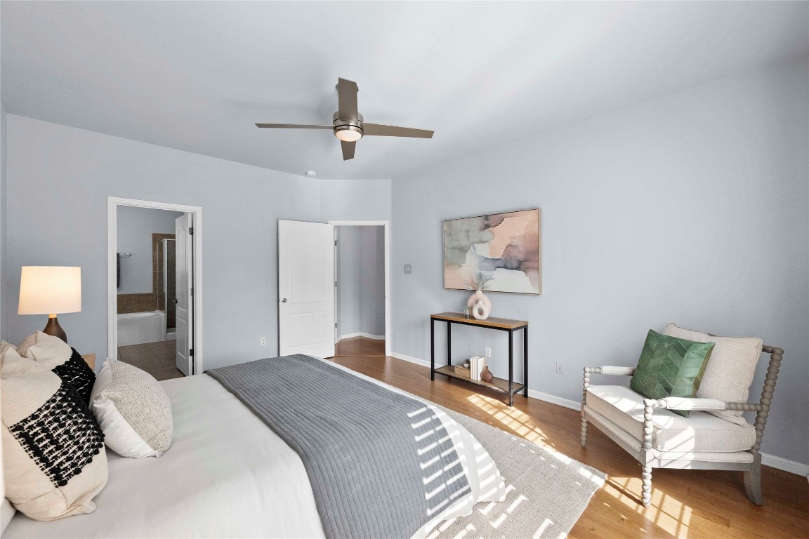 6704 Menchaca Road, Unit 29 Austin, TX 78745 - Photo 17 of 34 a bedroom with a bed wooden floor and lamp