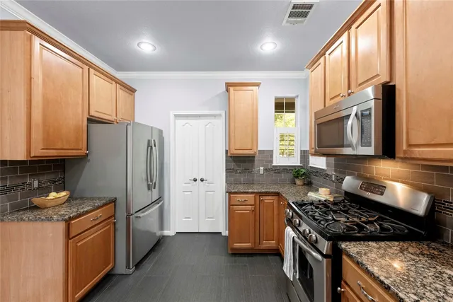 a kitchen with stainless steel appliances granite countertop a stove a refrigerator and a sink