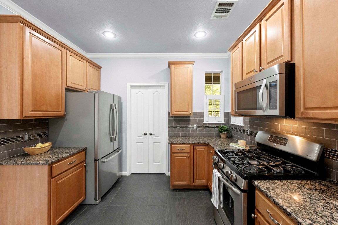 6704 Menchaca Road, Unit 29 Austin, TX 78745 - Photo 9 of 34 a kitchen with stainless steel appliances granite countertop a stove a refrigerator and a sink