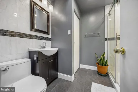 a bathroom with a sink a toilet and a mirror