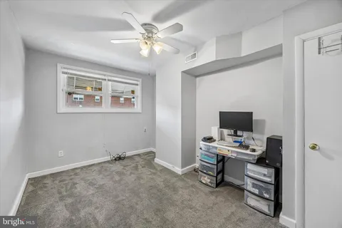 a workspace with white wall paintings and a window