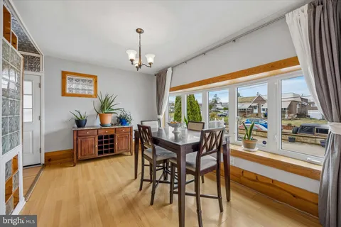 a dining room with furniture a chandelier and wooden floor