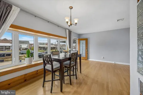 a dining room with furniture a chandelier and wooden floor