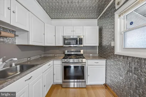 a kitchen with cabinets appliances and a sink