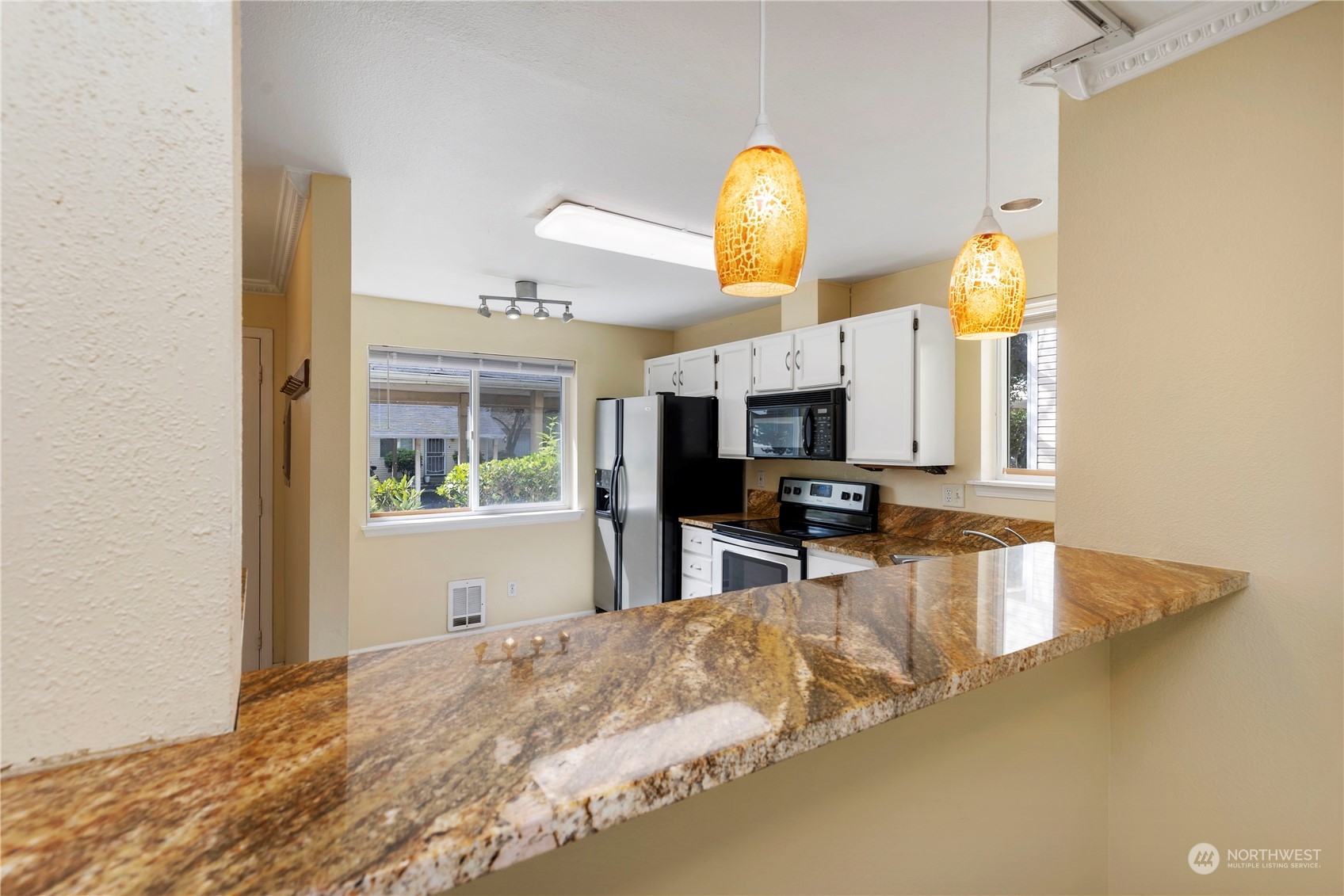 833 Southwest Sunset Boulevard, Unit M58 Renton, WA 98057 - Photo 8 of 24 a kitchen with stainless steel appliances granite countertop a sink and a stove