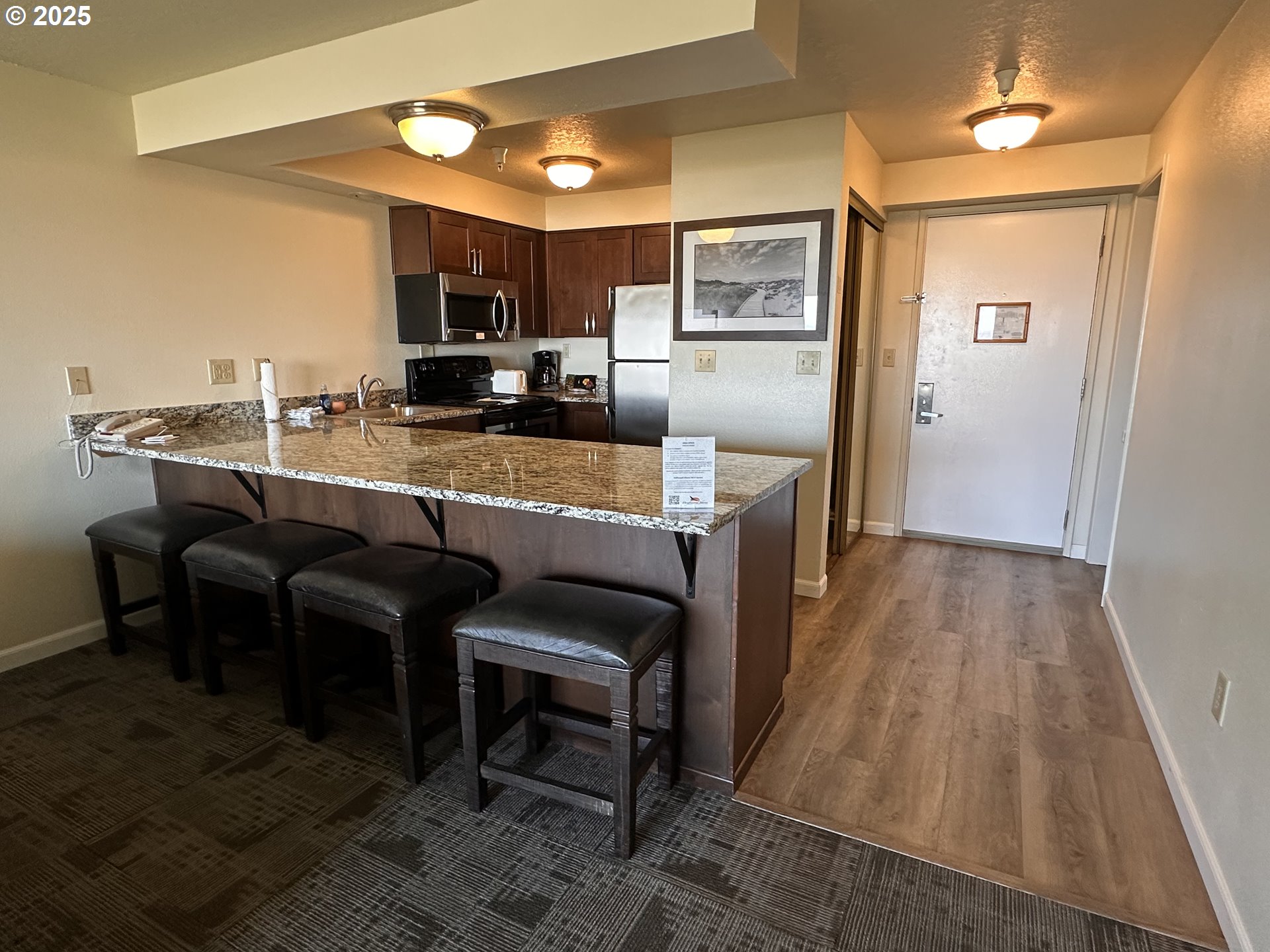 88416 1st Avenue, Unit 303 Florence, OR 97439 - Photo 11 of 21 a kitchen with kitchen island granite countertop wooden cabinets and stainless steel appliances