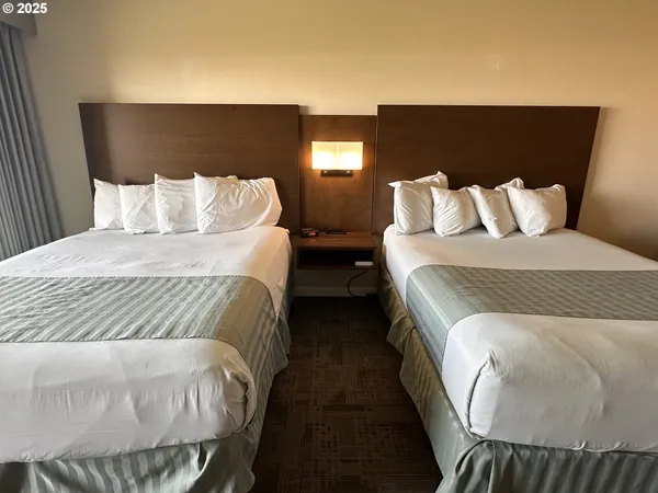 a large bed sitting in a bedroom next to a lamp