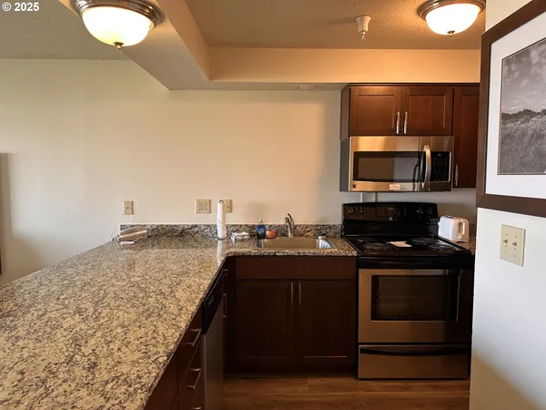 a kitchen with kitchen island granite countertop a stove top oven microwave and cabinets