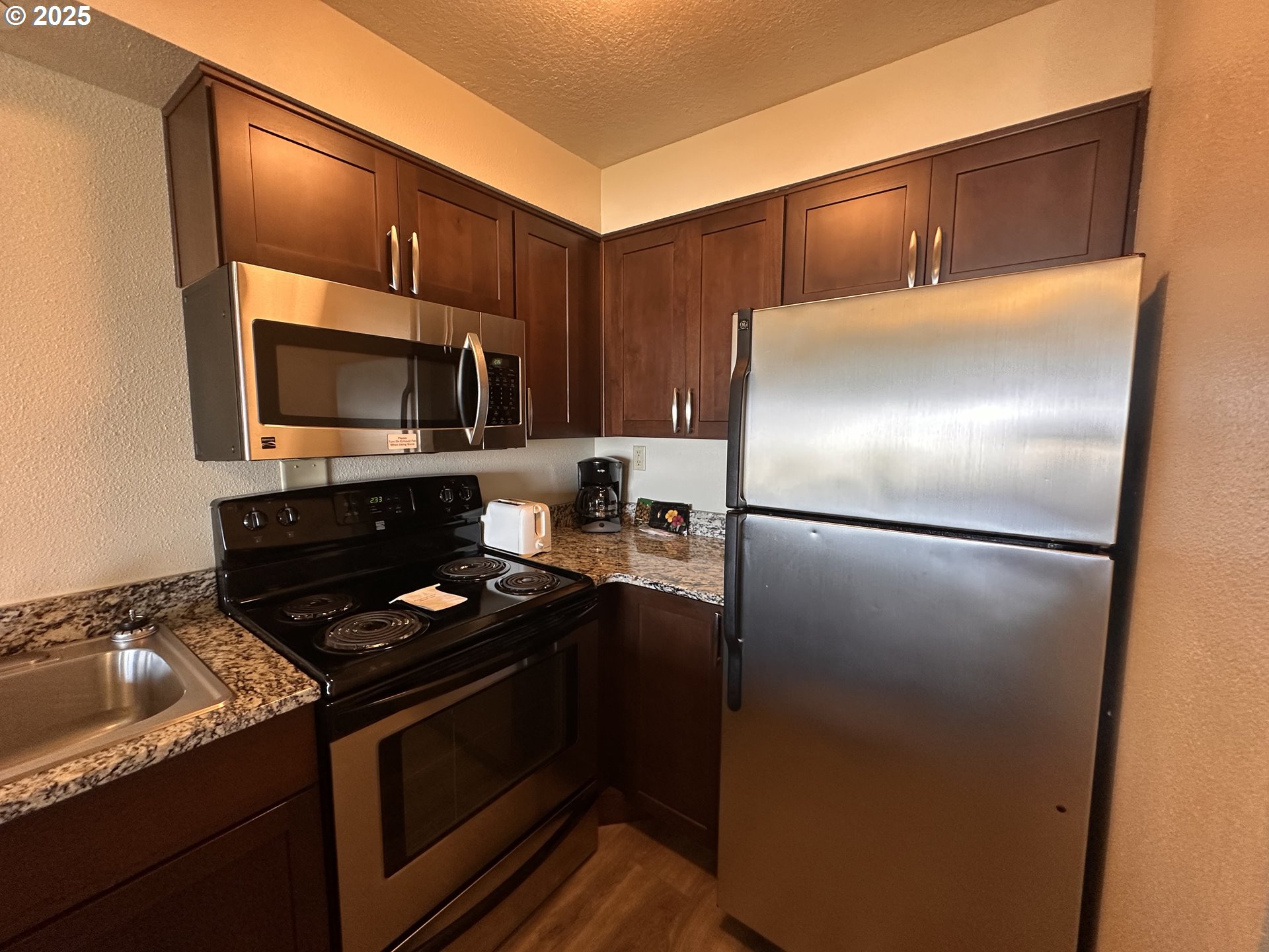 88416 1st Avenue, Unit 303 Florence, OR 97439 - Photo 7 of 21 a kitchen with a refrigerator and a stove top oven
