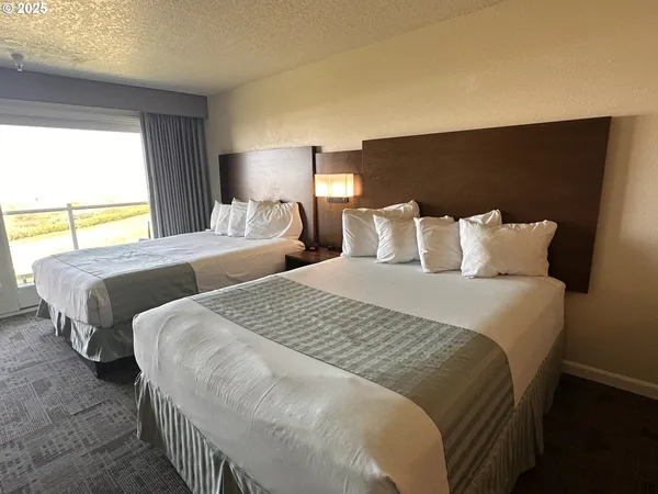 a bedroom with beds and a night stand