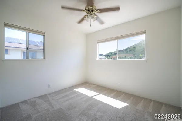 an empty room with a window and a ceiling fan