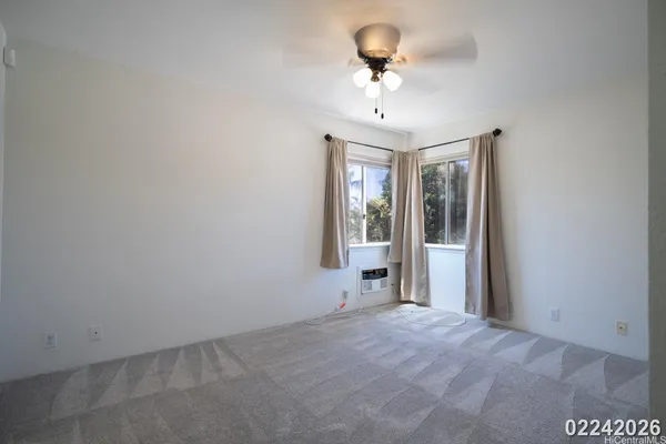 a view of a room with a chandelier fan and windows